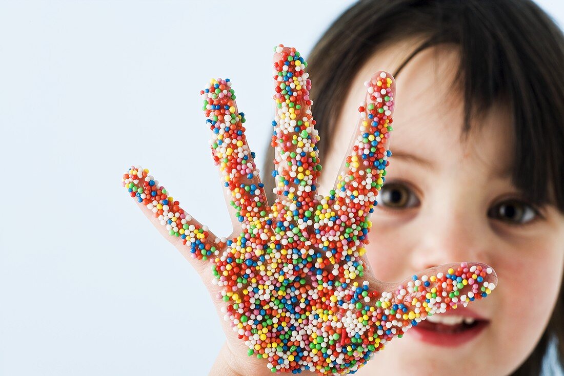 Girl with her hand covered in sprinkles