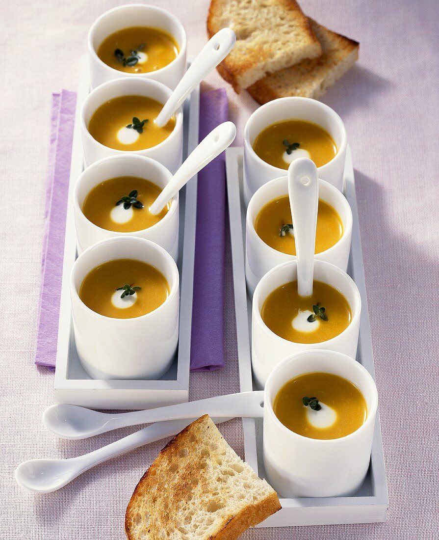 Cream of pumpkin soup in several small bowls