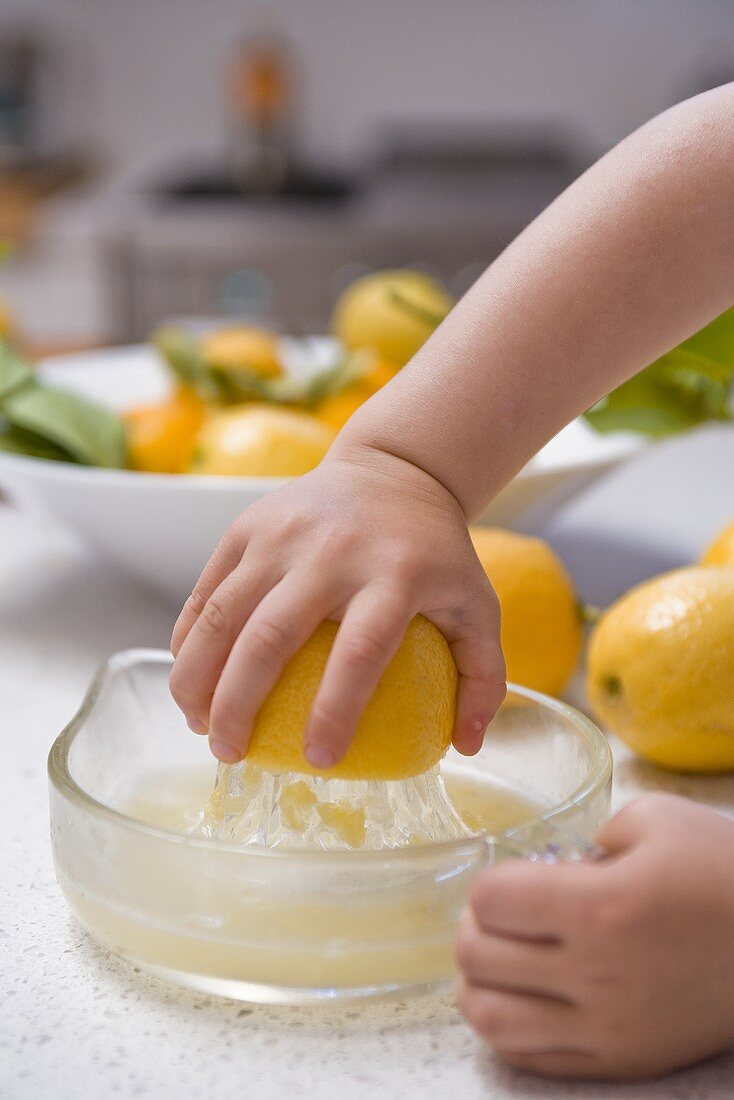 Kinderhand presst Zitrone aus