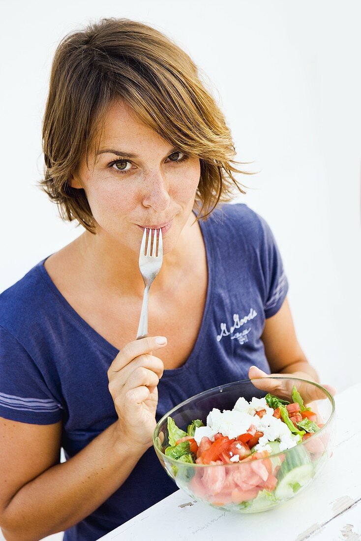 Young woman eating feta salad