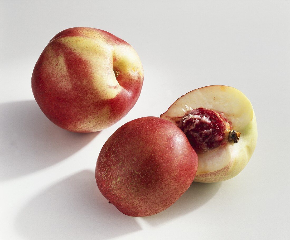 Whole and halved nectarine (variety: Zephir)