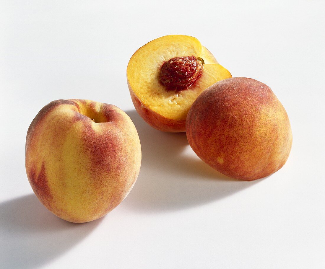 Whole and halved peach (variety: Hale)