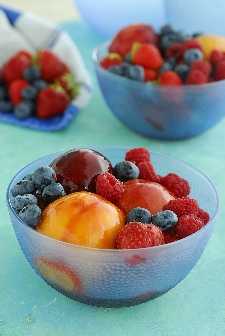 Glazed and fresh fruit in glass bowls