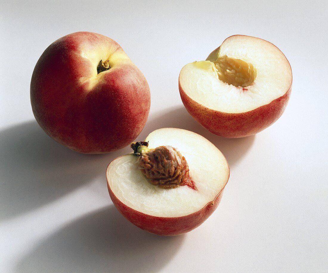 Whole and halved peach (variety: Fidelia)
