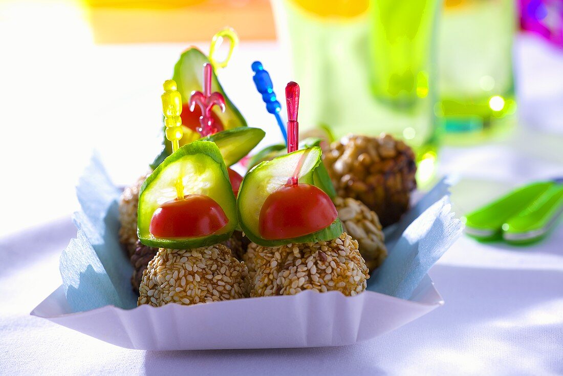 Sesame-coated meatballs, cucumber & tomatoes on cocktail sticks