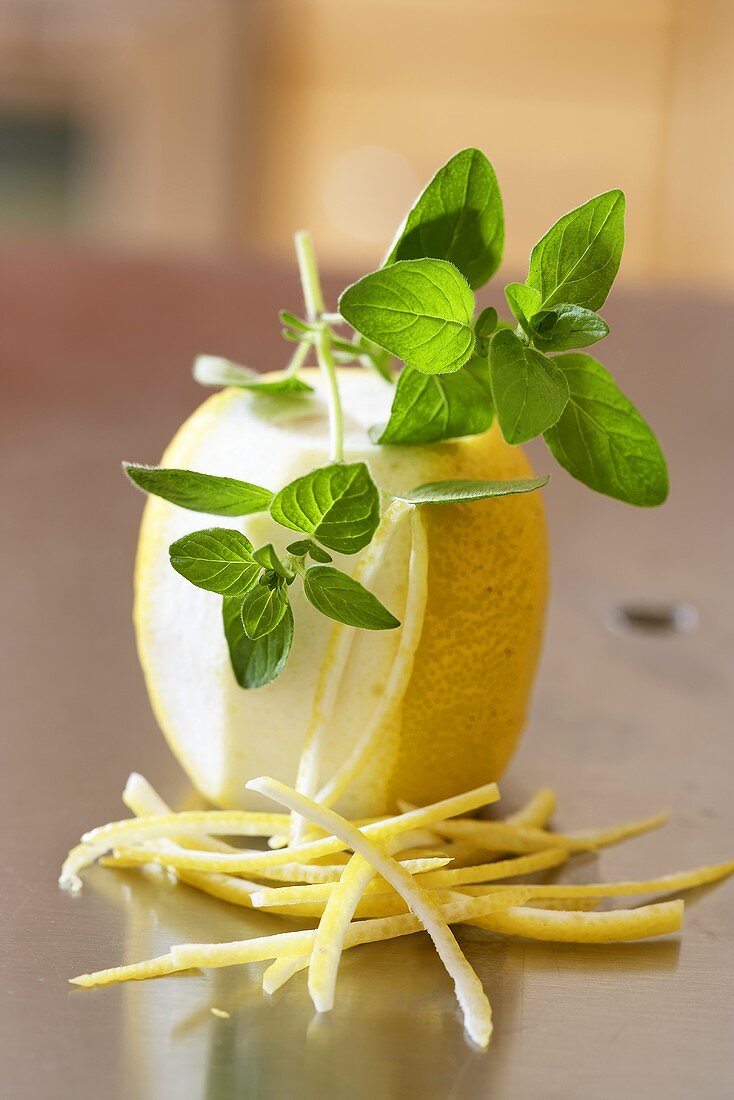 Lemon, partly peeled, lemon peel and oregano