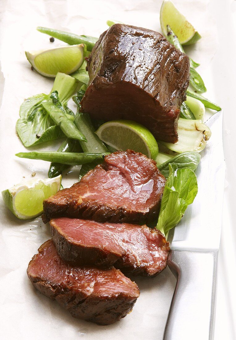 Beef fillet with pak choi and lime wedges