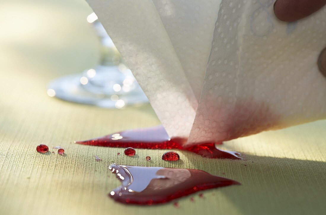 Mopping up spilt red wine with a paper towel