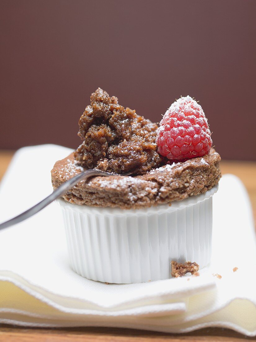 Schokoladensouffle in Backform und auf Löffel mit Himbeere