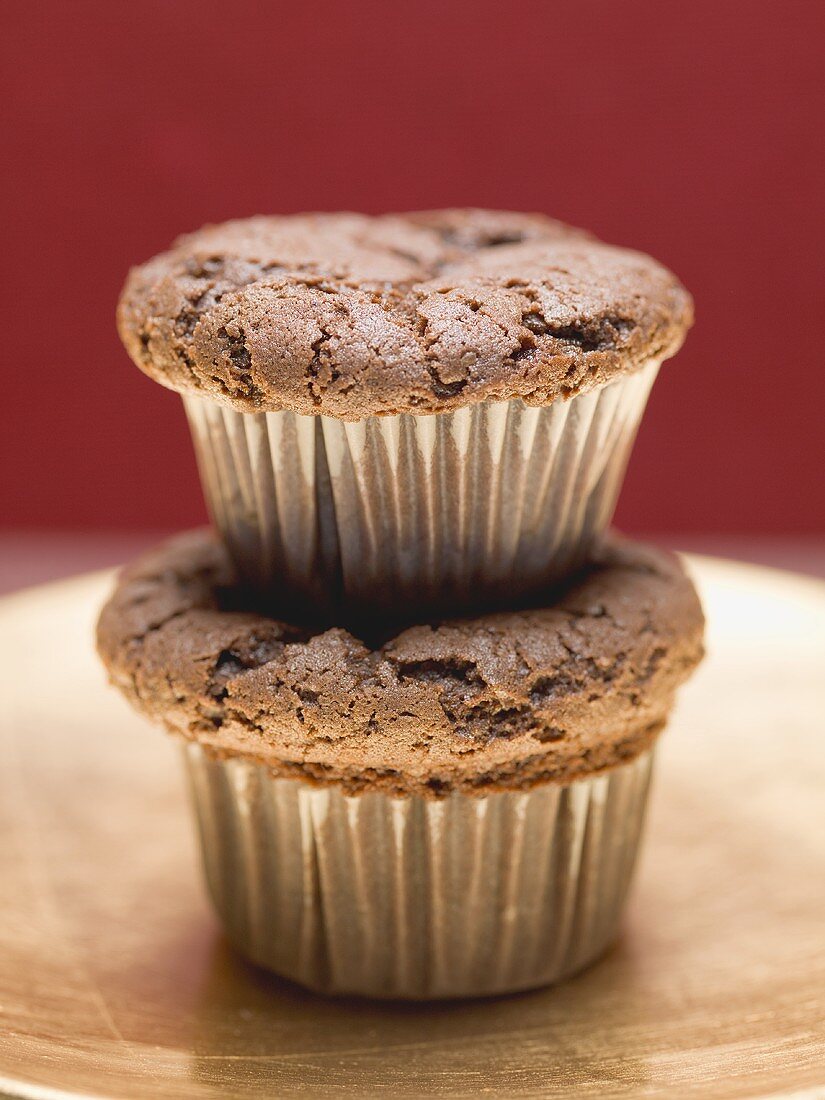 Two chocolate muffins, one on top of the other