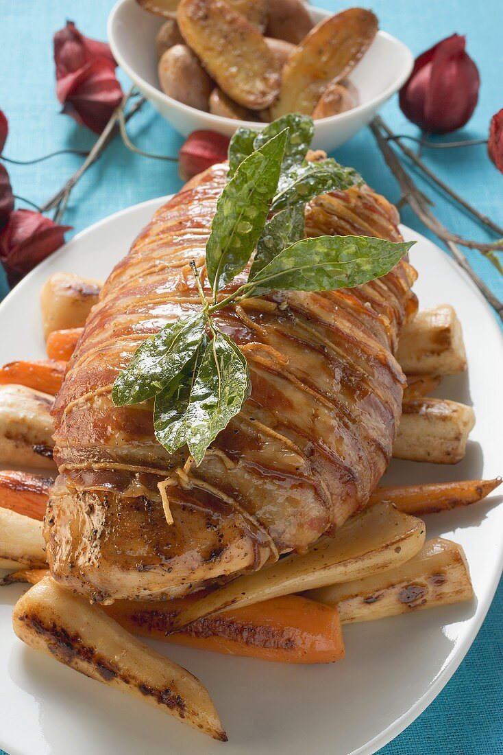 Bacon-wrapped turkey breast on roasted root vegetables