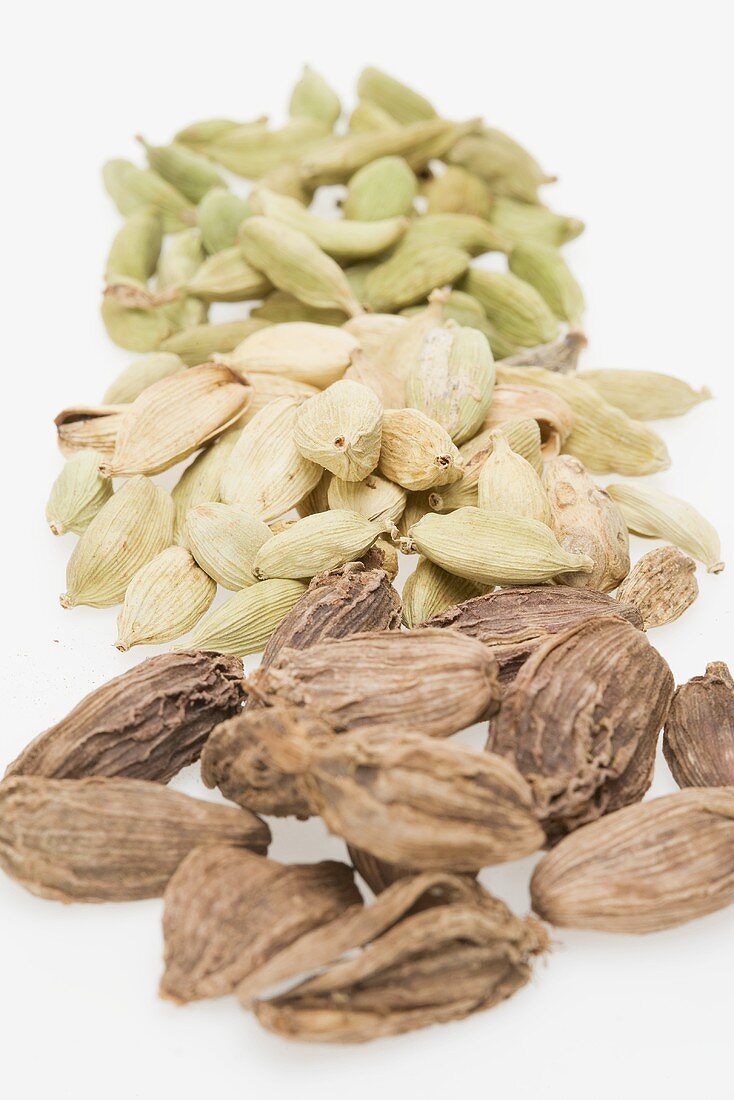 Green, brown and black cardamom pods