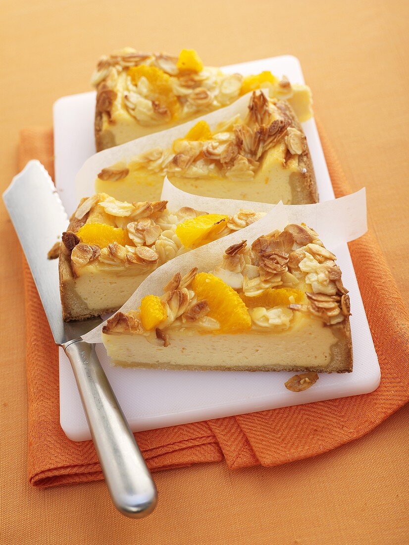 Four pieces of quark cake with orange segments & flaked almonds