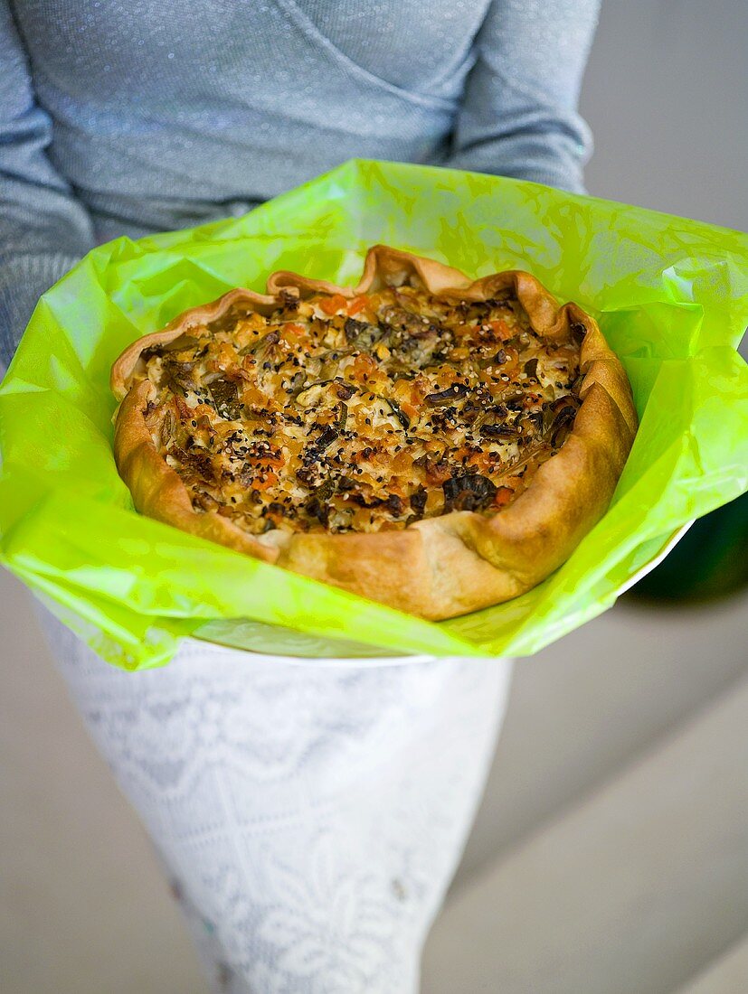 Woman holding freshly baked quiche