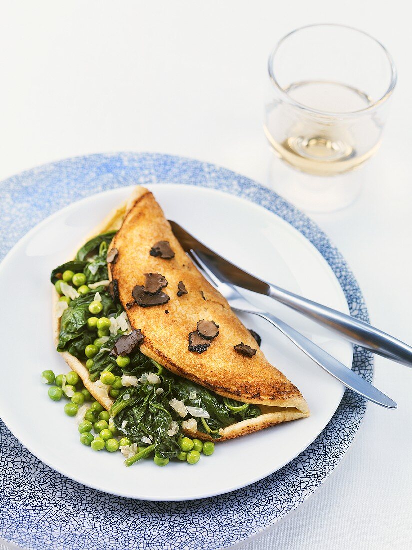 Soufflé omelette filled with spinach, peas and truffles
