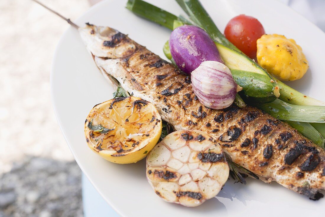 Grilled fish (Steckerlfisch) with vegetables and lemon