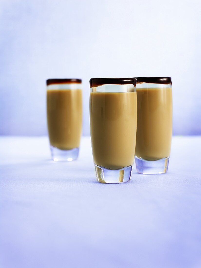 Drei Gläser Baileys mit Schokoladensauce am Glasrand