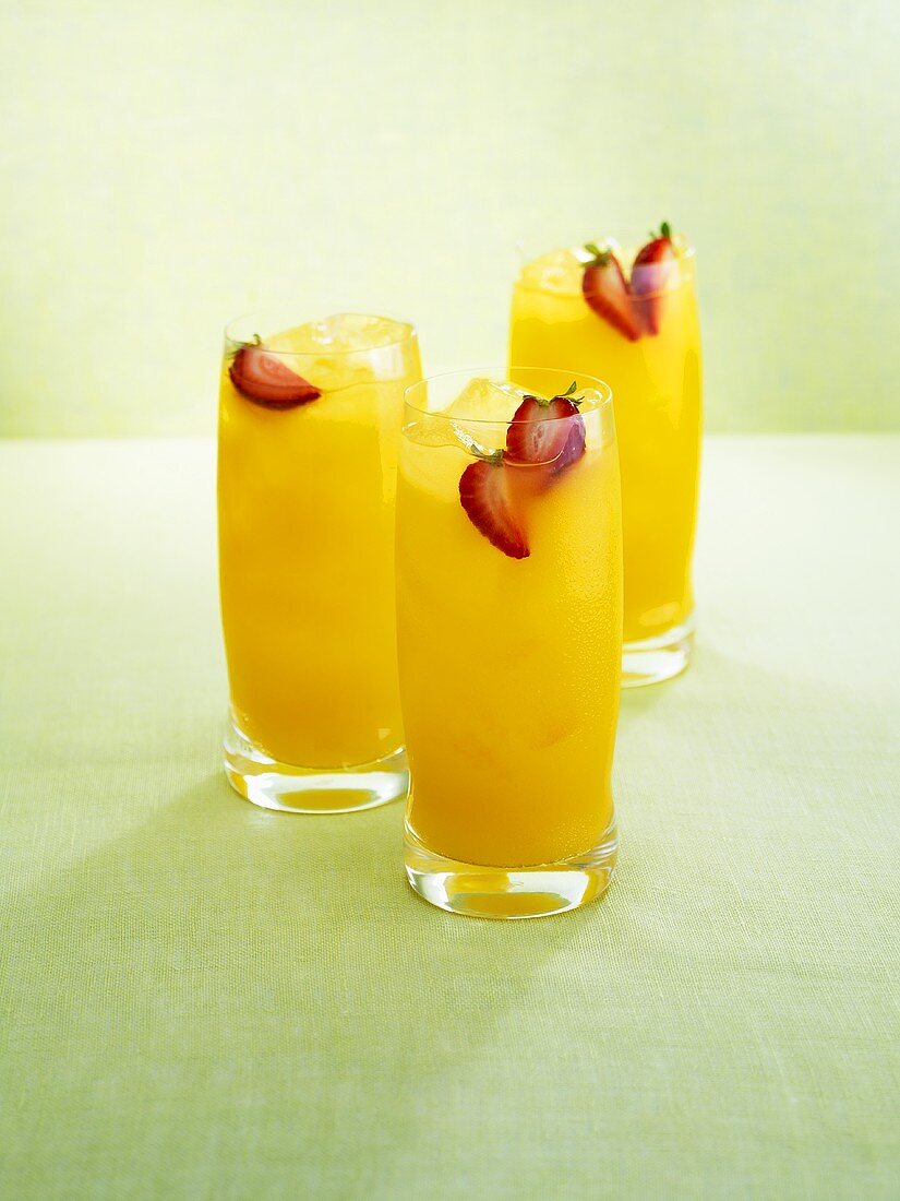 Drei fruchtige Drinks mit Rum, Karambolen und Erdbeeren