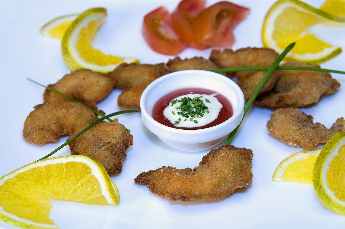 Breaded prawns with dip and slices of lime