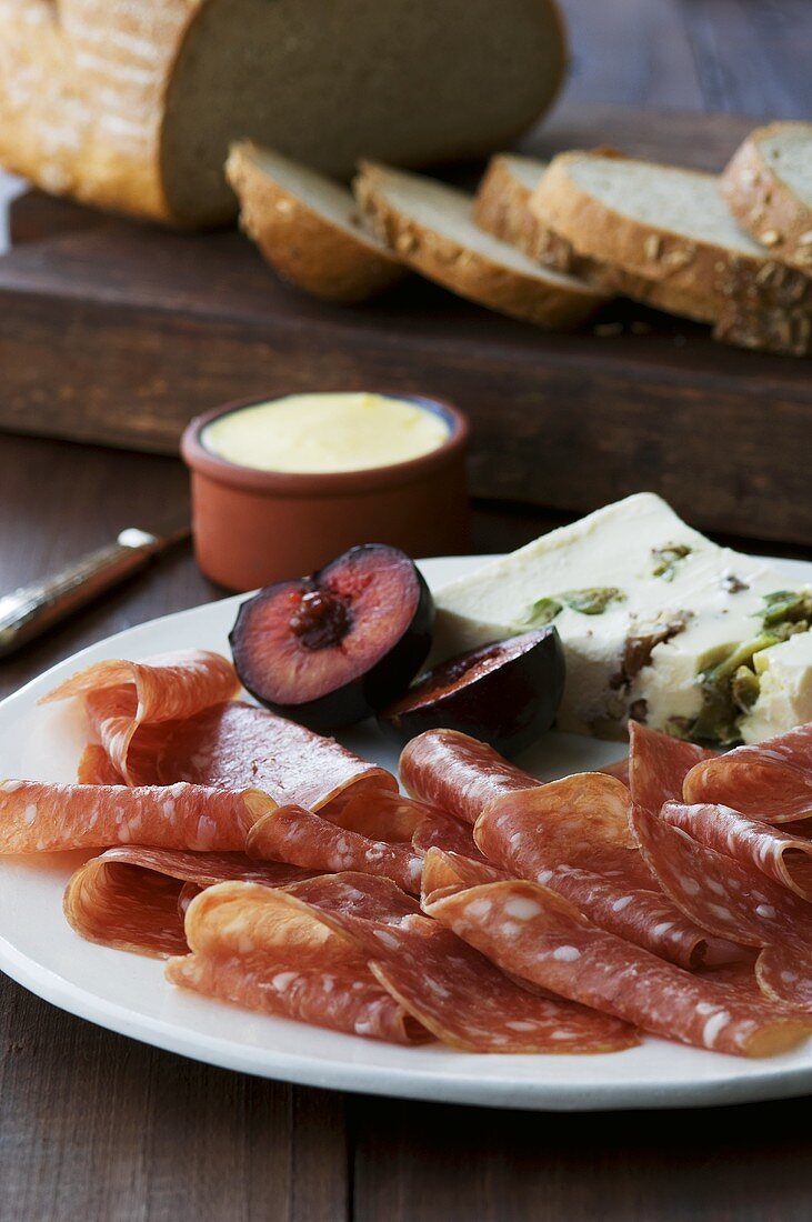 Salami, cheese and plums with bread and butter