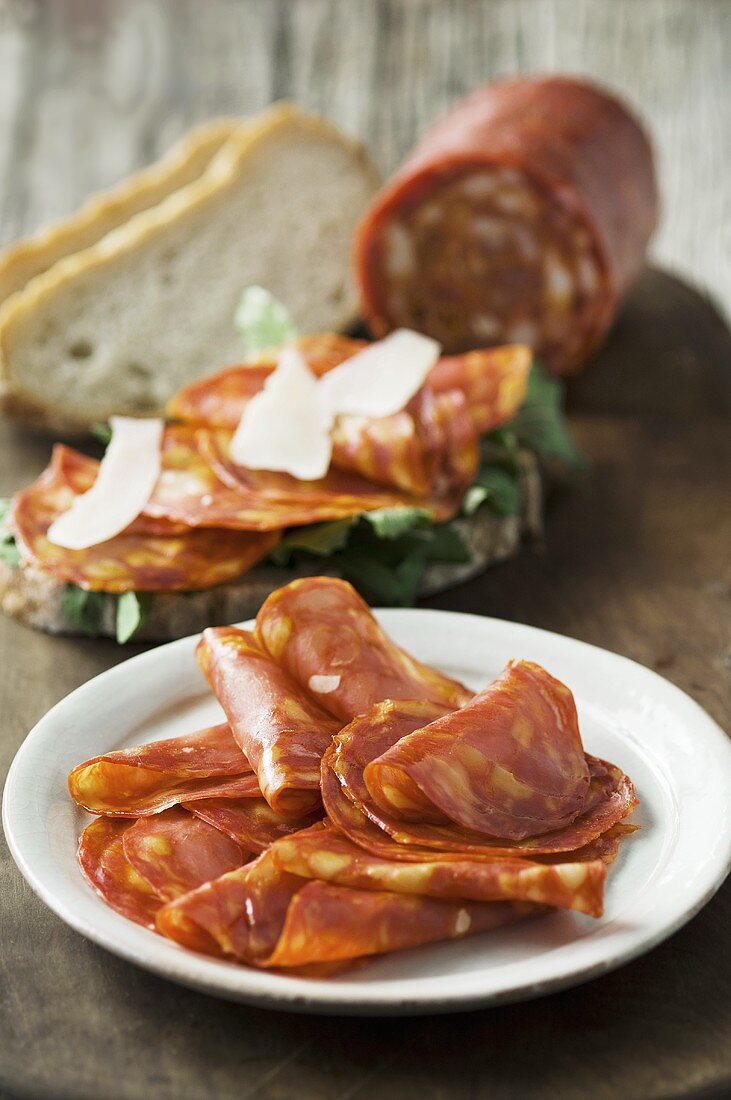 Sliced garlic sausage on bread and partly sliced sausage