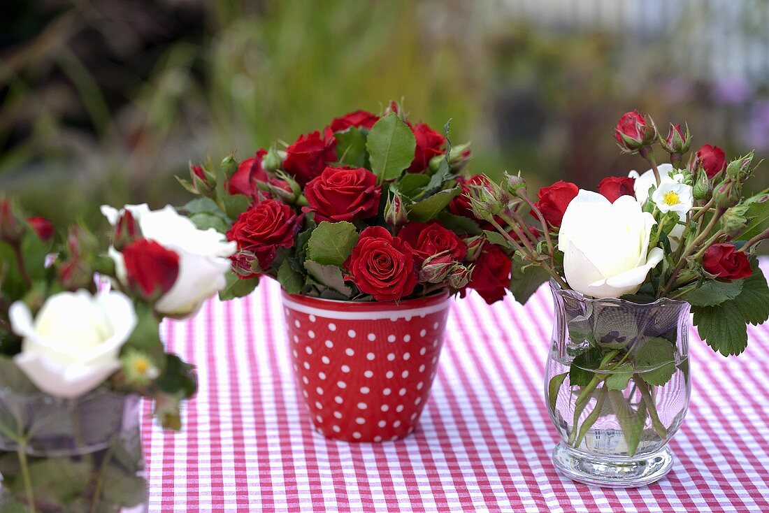 Verschiedene Rosensträusse auf Gartentisch