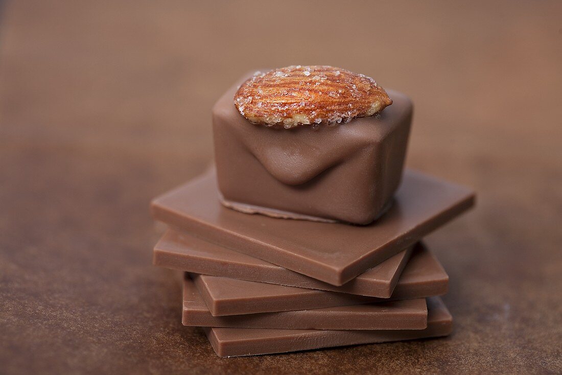 Chocolate pralines with almonds on squares of chocolate