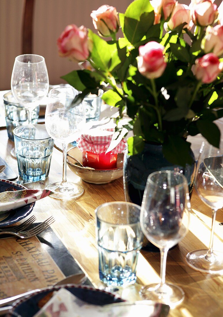 A rustically laid table with a bouquet of roses