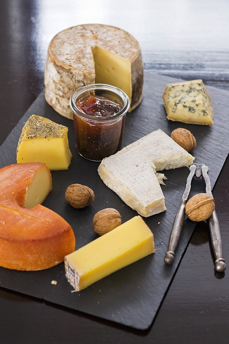 A cheese platter with nuts and jam