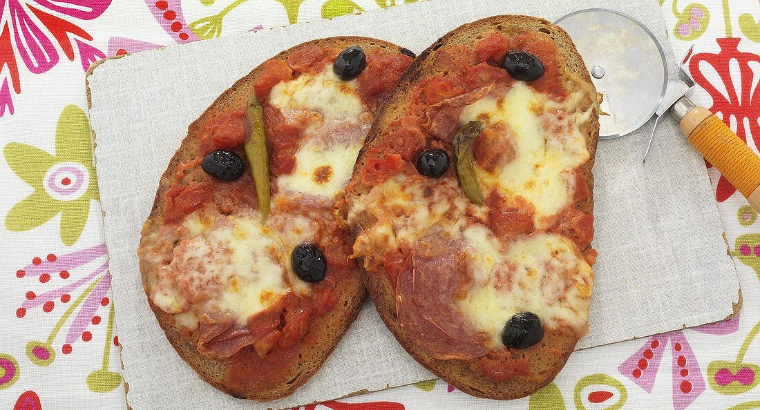 Pizza bread with salami, chillies and olives