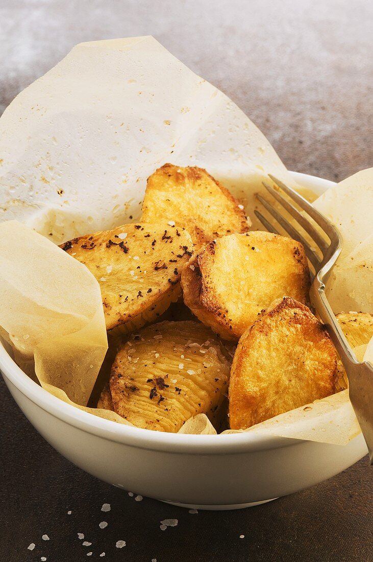 Roasted, salted potatoes in a paper-lined bowl