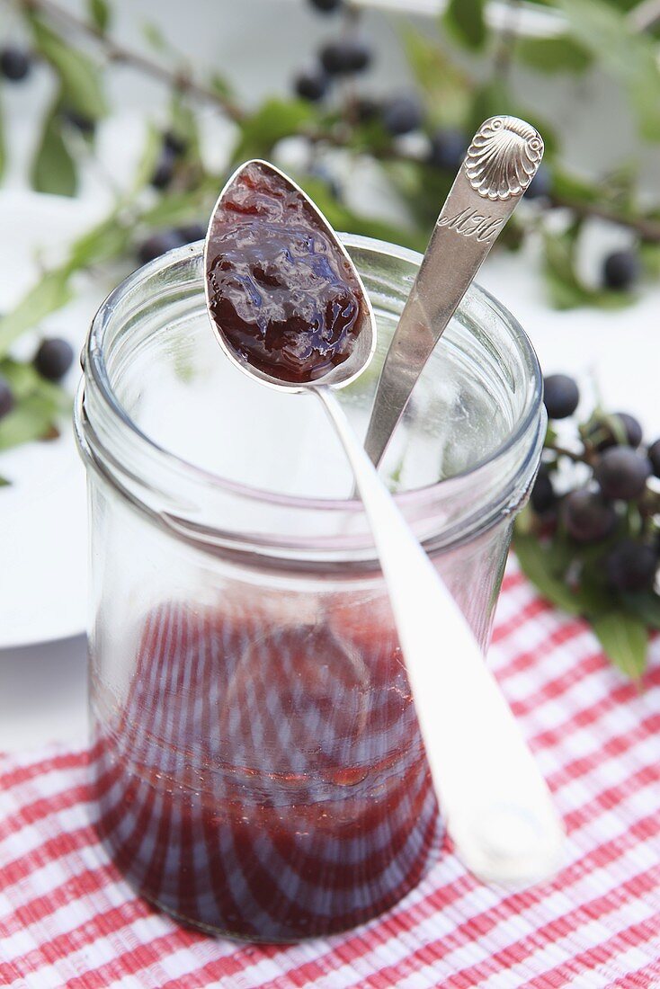 Blackthorn jelly in a jam jar with a spoon