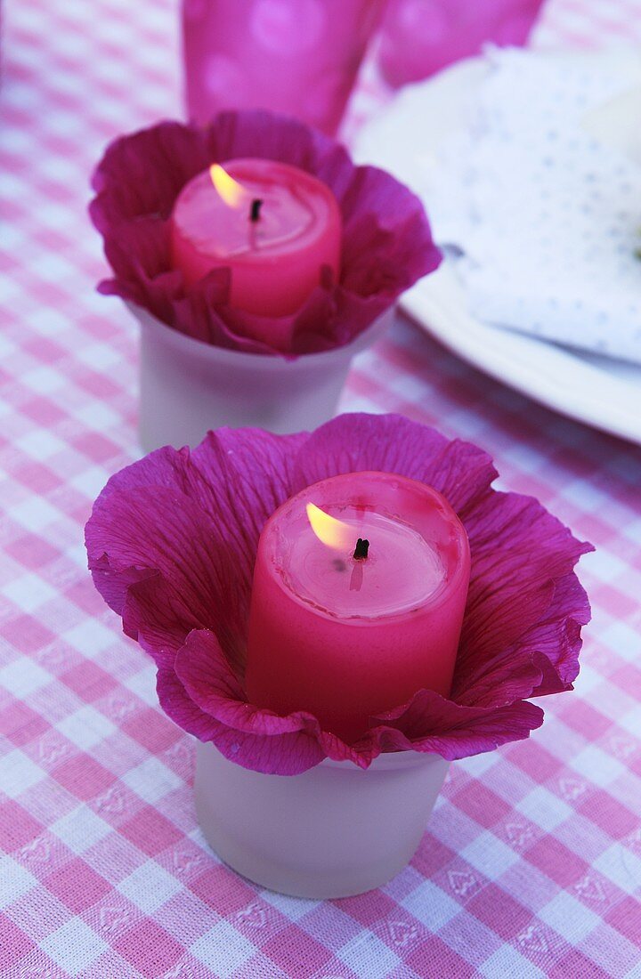 Kerzen in Stockrosenblüten als Tischdeko