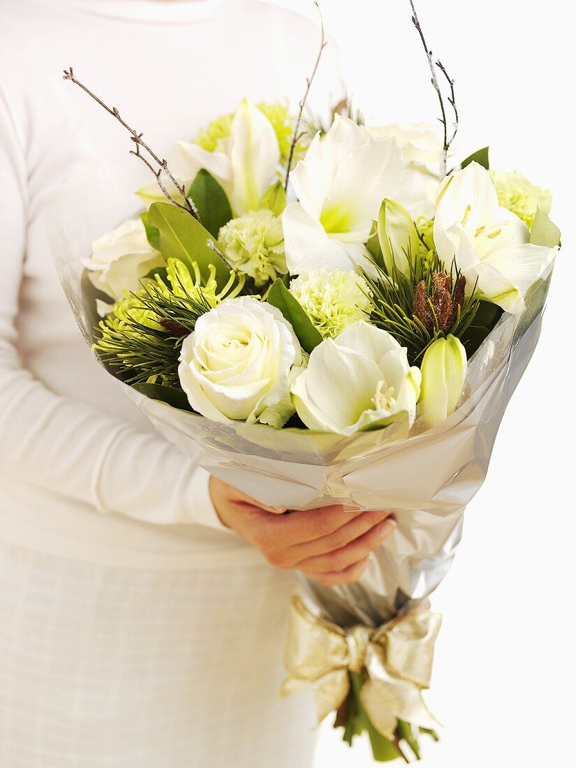 A woman holding a bunch of winter flowers