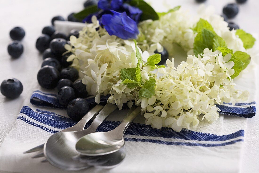 A wreath of hortensias and lemon balm next to blueberries