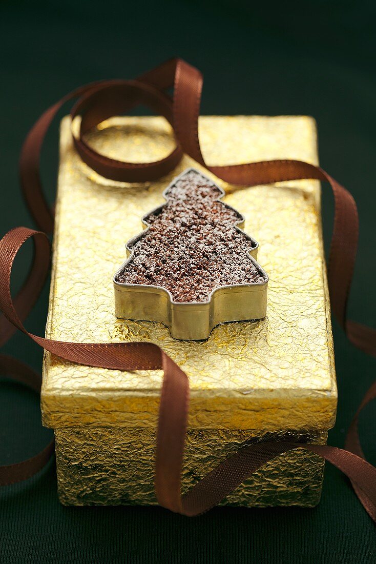 Schokoweihnachtsbäumchen auf goldener Geschenkbox