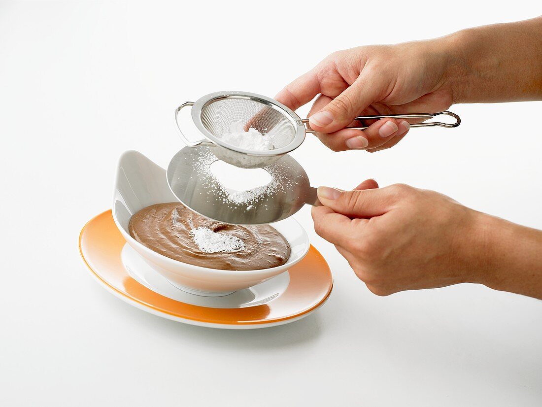 Chocolate pudding being decorated with a sugar heart