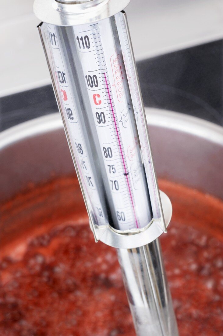 Testing the temperature of jam with a jam thermometer