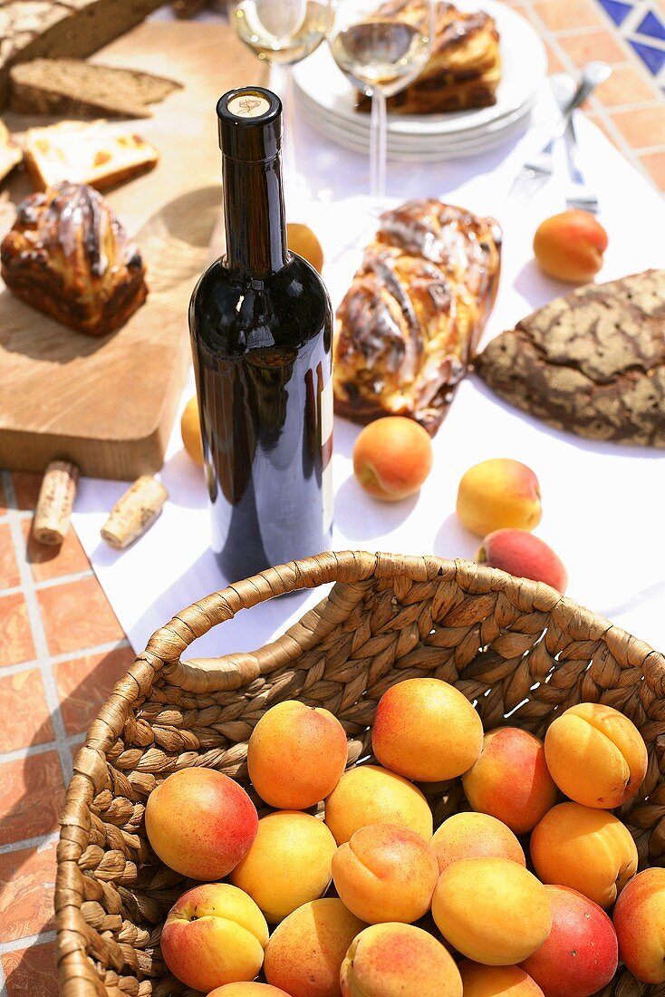 Frische Aprikosen, Weinflasche, Aprikosenkuchen und Brot