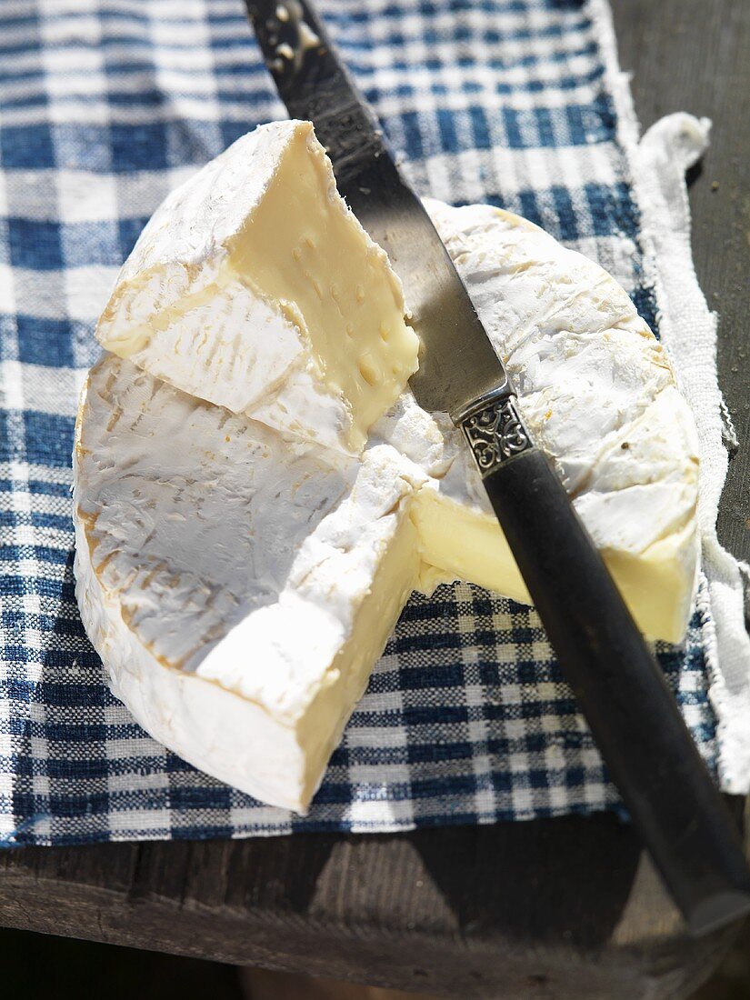 Camembert, angeschnitten, mit Messer