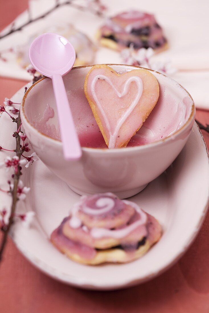 Heart-shaped biscuits with icing sugar and a sprig of almond flowers