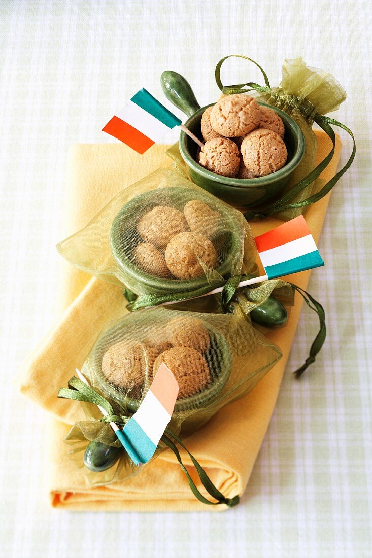 Amarettini in small bowls in satin bags with Italian paper flags as a present for guests