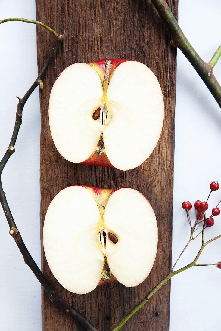 Two apple halves on a wooden surface