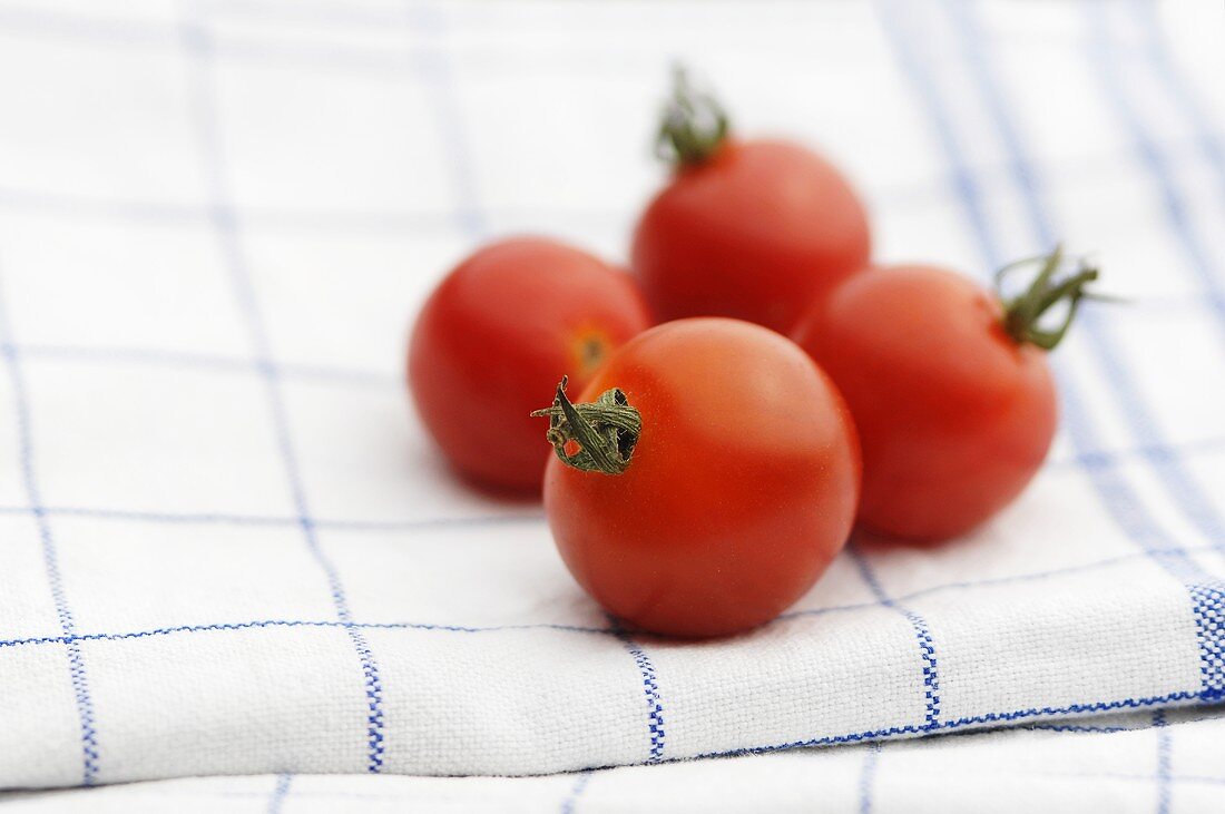 Four tomatoes on a dish cloth