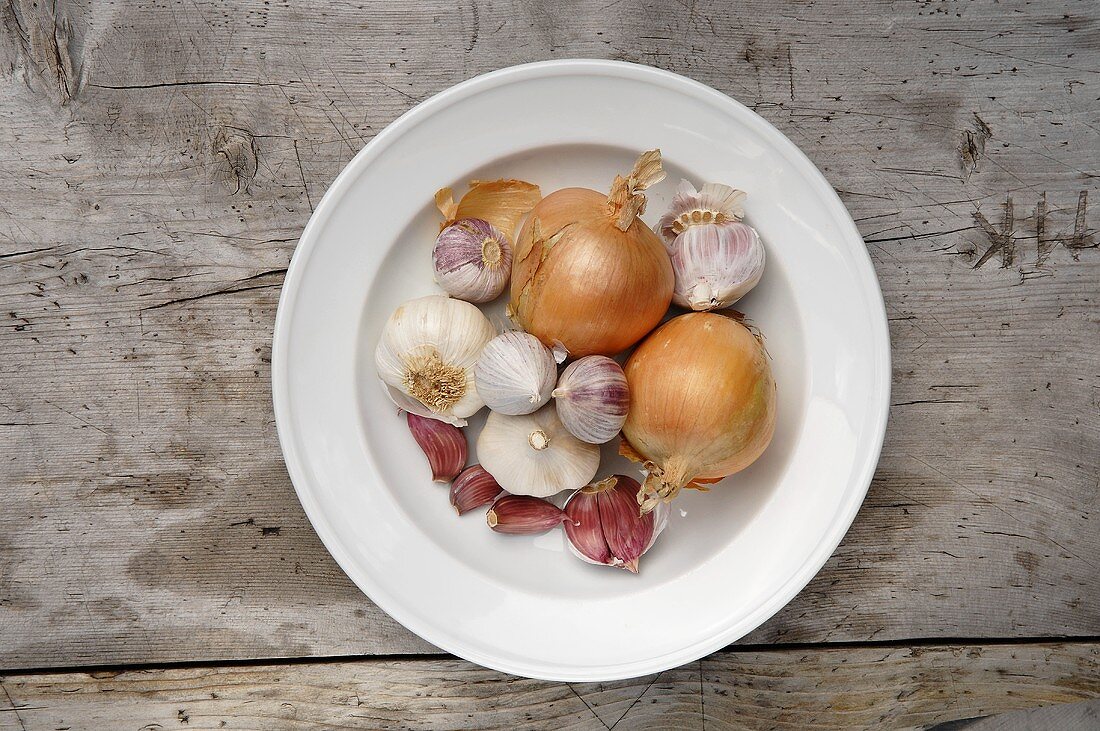 Onions and garlic on a plate, seen from above