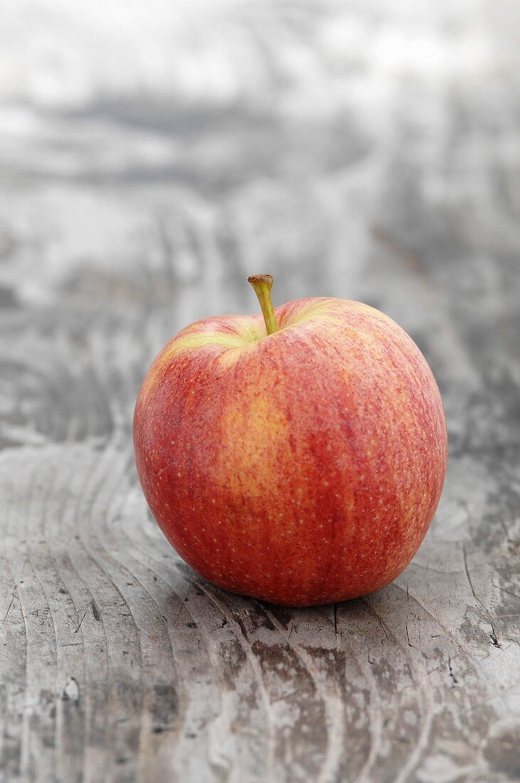 Ein Elstar Apfel auf Holzuntergrund