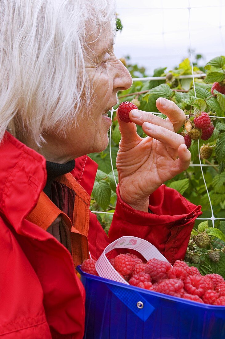 A woman eating raspberries