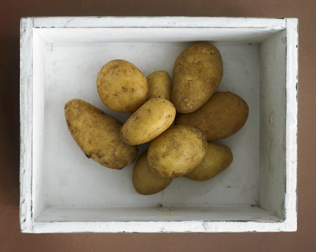 Fresh potatoes in a white wooden box