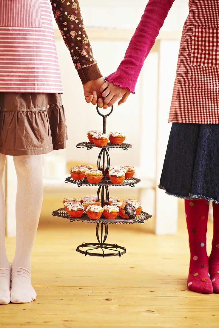 Kinder halten Etagere mit Advents-Cupcakes