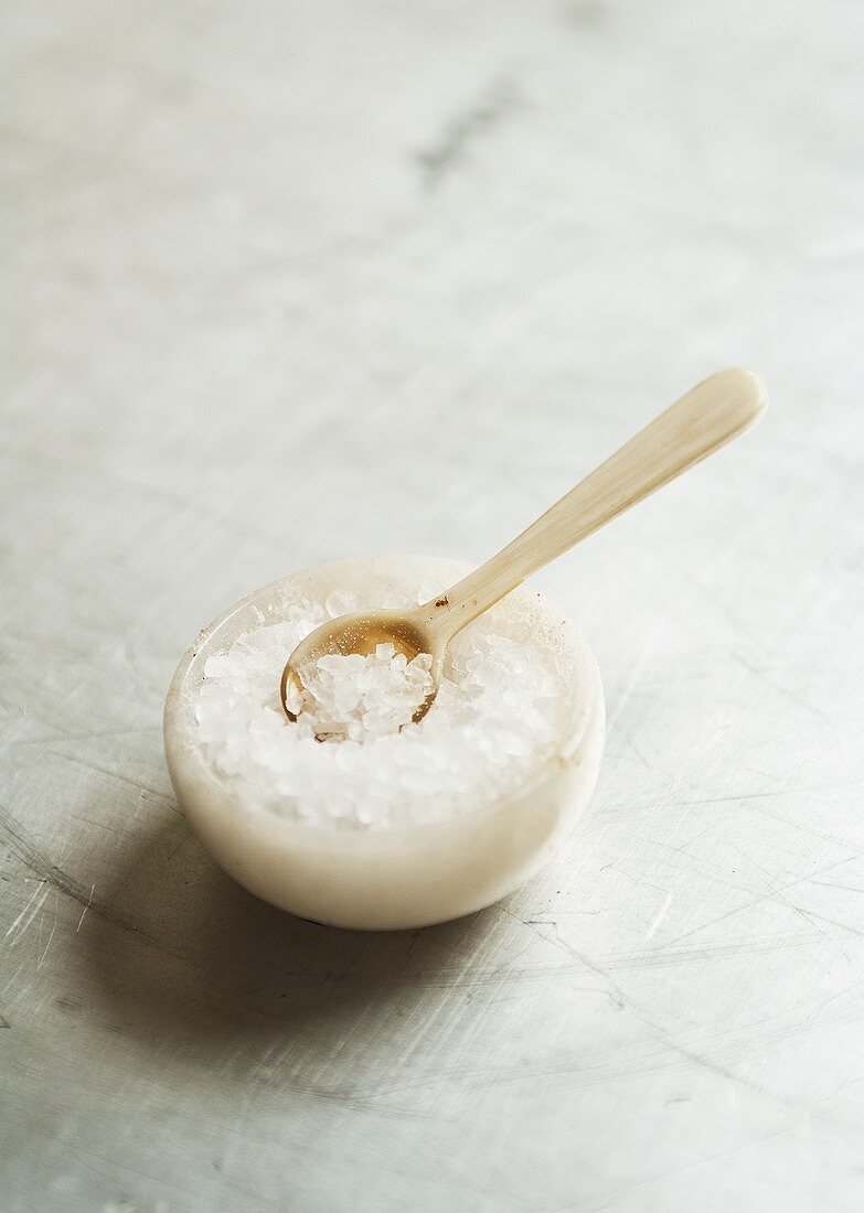 Coarse salt on a marble bowl with a spoon